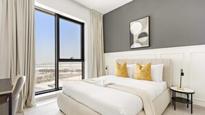 Ein modernes Hotelzimmer mit einem großen Bett, einem Schreibtisch und Blick auf die Stadt.