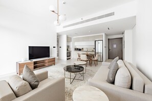 Ein modernes Wohnzimmer mit einer Couch, einem Couchtisch und einem Fernseher.