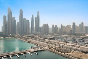 A cityscape with high-rise buildings, a marina, and a waterfront promenade. - Silkhaus 1bdr in Marina Vista Tower Private Beach (Dubai)