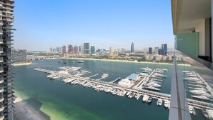 A marina with numerous boats docked, a city skyline in the background, and a clear blue sky. - Silkhaus 1BR in Emaar Tower With Private Pool (Dubai)