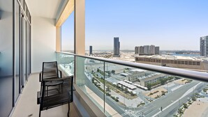 A balcony with a clear view of a cityscape, including high-rise buildings and a waterfront. - Silkhaus in Julphar Cozy 1bdr In Reem Island (Abu Dhabi)
