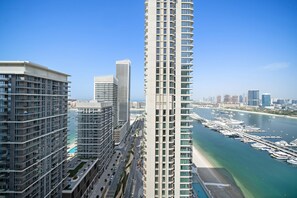 A high-rise building with a marina and waterway in the background. - Silkhaus in Marina Vista Stunning 1bdr Sea View (Dubai)