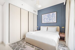A modern bedroom with a large bed, a nightstand with a lamp, and a wardrobe. - Silkhaus in Marina Vista Stunning 1bdr Sea View (Dubai)