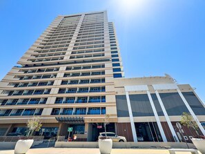 A modern high-rise building with multiple floors, large windows, and a prominent entrance area with a sign. - Silkhaus Near Reem Island Mall Julphar Tower (Abu Dhabi)