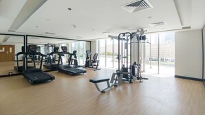 Une salle de sport équipée de tapis de course, de vélos elliptiques et de matériel de musculation.