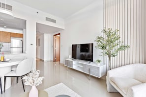 Uma sala de estar moderna com televisão, sofá e área de refeições.