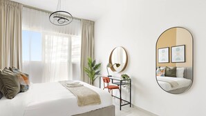 A modern bedroom with a large bed, a desk, a chair, a mirror, and a window with curtains. - Silkhaus Bayside 1bdr Stay Marina Bay Tower (Abu Dhabi)
