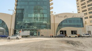 A tall, modern building with a glass facade and a curved entrance. - Silkhaus Bayside 1bdr Stay Marina Bay Tower (Abu Dhabi)