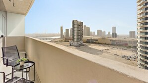 A balcony with a view of a cityscape, including a distinctive building with a unique design. - Silkhaus Bayside 1bdr Stay Marina Bay Tower (Abu Dhabi)