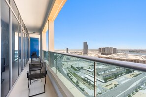 A balcony with a view of a cityscape, including high-rise buildings and a river. - Silkhaus 2bdr Retreat Julphar Tower Al Reem (Abu Dhabi)