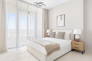 A modern bedroom with a large bed, two bedside tables, and a view through floor-to-ceiling windows. - Silkhaus 2bdr Retreat Julphar Tower Al Reem (Abu Dhabi)