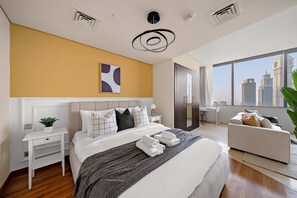 A modern hotel room with a large bed, a bedside table with a plant, a desk, a sofa, and a large window with a city view. - Silkhaus Sky Gardens Homestyle Studio Difc (Dubai)