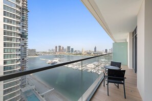 Un balcone con vista su un porto turistico e sullo skyline cittadino.