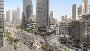 A cityscape with modern high-rise buildings, a busy intersection, and a pedestrian walkway. - Silkhaus Luxury Studio Sky Gardens Difc Views (Dubai)