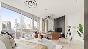 A modern hotel room with a large bed, a desk, a chair, a TV, and a balcony with a city view. - Silkhaus Luxury Studio Sky Gardens Difc Views (Dubai)