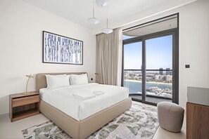 A modern hotel room with a large bed, a city view, a framed artwork, and a nightstand with a lamp. - Silkhaus Family Friendly 2bdr Private Beach (Dubai)