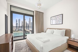 A hotel room with a large bed, a desk, a chair, and a view of a cityscape through a large window. - Silkhaus Family Friendly 2bdr Private Beach (Dubai)