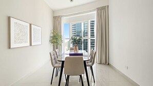 A modern dining room with a glass table, six chairs, and two framed artworks on the wall. - Silkhaus Elite 2bdr at Sigma I in Al Reem Island (Abu Dhabi)