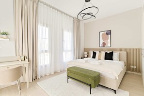 A modern bedroom with a bed, bedside table, lamp, and a desk with a chair. - Silkhaus Luxe 2 BDR Maid Room Springs 7 Villa (Dubai)
