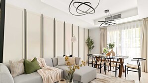 Uma sala de estar moderna com sofá, mesa de centro e área de jantar.