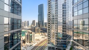 A high-rise building with a modern glass facade, surrounded by other high-rise buildings and a clear sky. - Silkhaus 1bdr in Reem Island in New Modern Tower (Abu Dhabi)