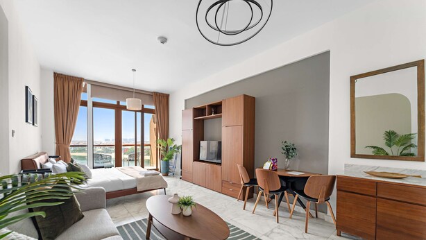 A modern living room with a sofa, coffee table, and dining area. - Silkhaus Chic Studio in Palm Jumeirah Sea View (Dubai)