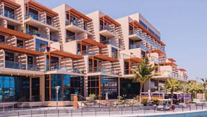 A multi-story hotel with balconies, large windows, and a pool area. - Silkhaus Chic Studio With Pool and Gym (Dubai)