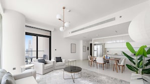 A modern living room with a large window, a dining area, and a kitchen. - Silkhaus Spacious 2BR Marina Vista Tower Beach (Dubai)