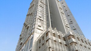 A tall, modern building with a prominent vertical design and multiple balconies. - Silkhaus Horizon Tower Big 1bdr Near Al Fay Park (Abu Dhabi)