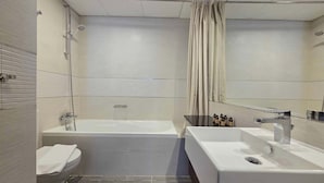 A modern bathroom with a bathtub, a sink, and a toilet. - Silkhaus Signature 1BR in Reem Island Gate Tower (Abu Dhabi)