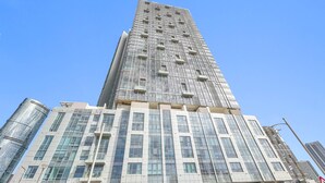 A modern high-rise building with a unique facade, large windows, and a prominent entrance. - Silkhaus Premier 2BR Stay Near Reem Central Park (Abu Dhabi)
