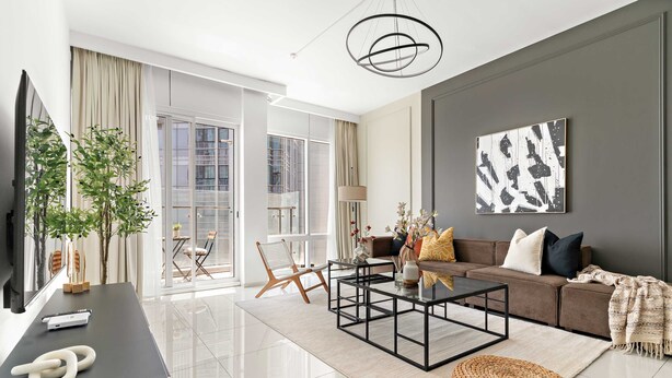 A modern living room with a sofa, coffee table, and a large window. - Silkhaus Premier 2BR Stay Near Reem Central Park (Abu Dhabi)
