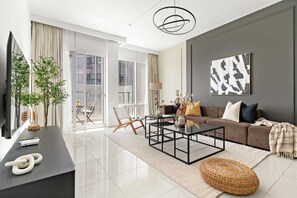 A modern living room with a sofa, coffee table, and a large window. - Silkhaus Premier 2BR Stay Near Reem Central Park (Abu Dhabi)