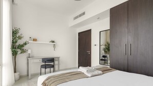 Une chambre à coucher moderne, avec un lit, un bureau et une armoire.