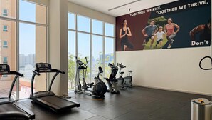 Ett gym med löpband, motionscyklar och en motiverande affisch på väggen.