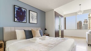 Quarto de hotel moderno com uma cama grande, vista da cidade e obras de arte na parede.