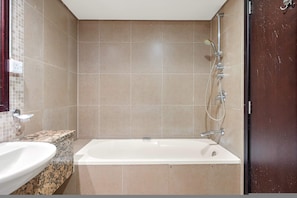 A bathroom with a bathtub, a sink, and a shower. - Silkhaus Exclusive 1bdr Stay Sky Gardens in Difc (Dubai)