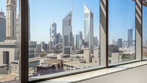 Vista panorámica de la ciudad desde un edificio alto, con modernos rascacielos y una destacada torre del reloj.