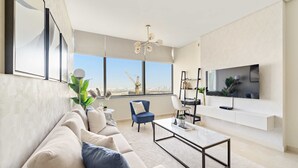 A modern living room with a sofa, coffee table, and a TV mounted on the wall.