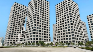 Un moderno edificio de gran altura con fachada de entramado, varios pisos y techo plano.