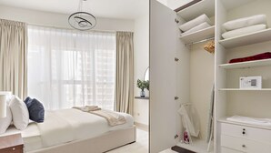 A bedroom with a bed, a wardrobe, and a bedside table. - Silkhaus Premium 2bdr Stay in Al Reem Island (Abu Dhabi)
