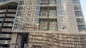 A high-rise building with a modern glass facade, multiple floors, and a prominent entrance at the base. - Silkhaus Lavish 3bdr Stay in Radiant Boulevard (Abu Dhabi)