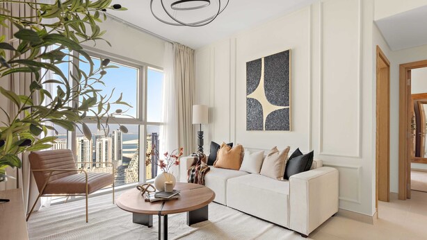 A modern living room with a white sofa, a round coffee table, and a large window offering a city view. - Silkhaus Lavish 3bdr Stay in Radiant Boulevard (Abu Dhabi)