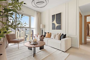 Ein modernes Wohnzimmer mit einem weißen Sofa, einem runden Couchtisch und einem großen Fenster mit Blick auf die Stadt.