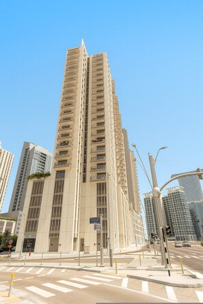 A tall, modern building with a symmetrical facade, multiple balconies, and a prominent entrance with a sign. - Silkhaus New 1bdr Minutes Walk to Reem Beach (Abu Dhabi)