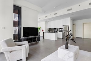 Ein modernes Wohnzimmer mit Flachbildfernseher, einer Couch und einem Couchtisch.