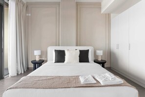 A hotel room with a large bed, two bedside tables with lamps, a window with curtains, and a wardrobe. - Silkhaus Unique 2bdr Beach Access in Pixel Tower (Abu Dhabi)