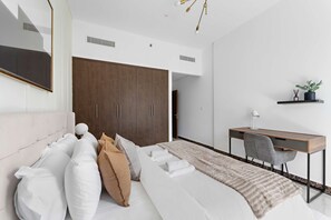 Ein modernes Schlafzimmer mit Bett, Schreibtisch und Kleiderschrank.