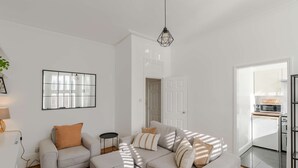 Ein Wohnzimmer mit einer Couch, einem Couchtisch, einer Lampe und einem gerahmten Bild an der Wand.