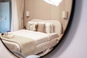 A neatly made bed with white linens and several pillows, a bedside table with a lamp, and a blue wardrobe in a hotel room. - Stayshort - Stunning Studio Unit in Business Bay That Sleeps 2 (Dubai)